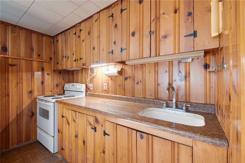225 Pine Slopes Road Acme, PA 15610 - Photo 12 of 24 a kitchen with stainless steel appliances granite countertop a sink a stove and a wooden cabinets