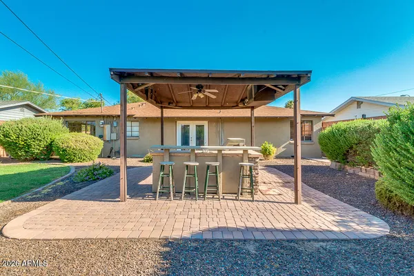 a view of a patio with table and chairs under an umbrella