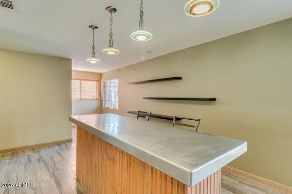 an empty room with a chandelier fan and windows