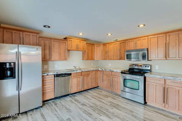 an empty room with a chandelier fan and windows