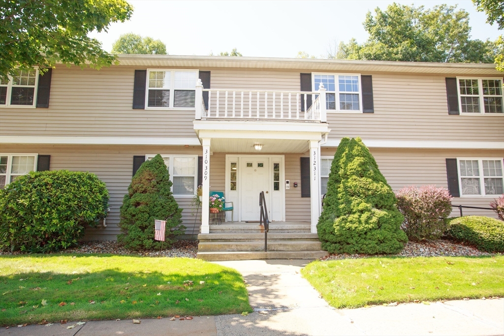 665 Center Street, Unit 311 Ludlow, MA 01056 - Photo 1 of 24 a front view of a house with a yard