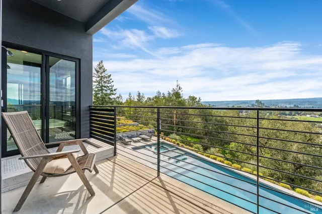 a view of a balcony with wooden floor next to a yard