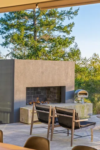 an outdoor living area with furniture and a fireplace