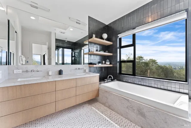 a bathroom with a large tub a sink and mirrors