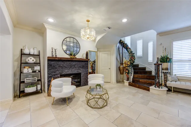 a living room with furniture a fireplace and a chandelier