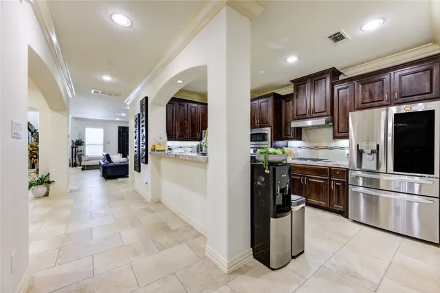 a kitchen with stainless steel appliances kitchen island granite countertop a refrigerator and a stove top oven