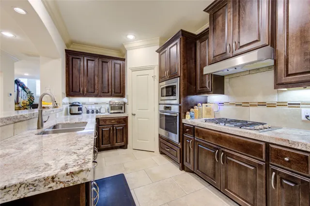 a kitchen with stainless steel appliances granite countertop a stove top oven a sink and dishwasher