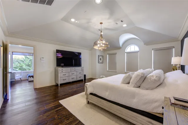 a bedroom with bed tv and a window