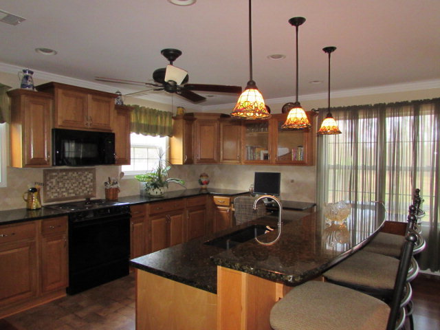 420 Fairview Church Road Forsyth, GA 31029 - Photo 2 of 12 a kitchen with stainless steel appliances granite countertop a sink a stove and a wooden floors