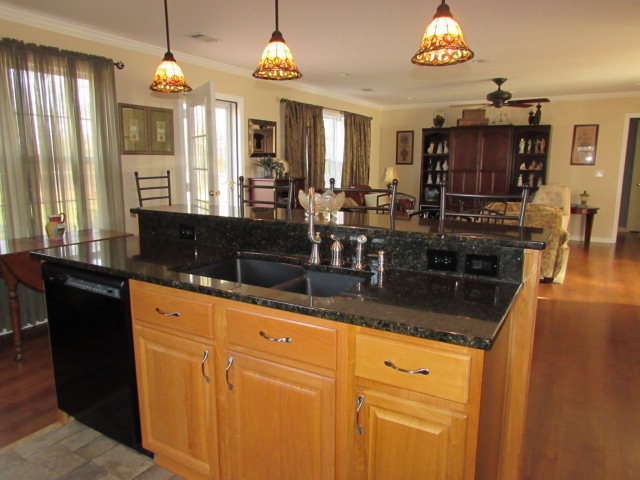420 Fairview Church Road Forsyth, GA 31029 - Photo 5 of 12 an open kitchen with granite countertop a sink dishwasher a dining table and chairs with wooden floor