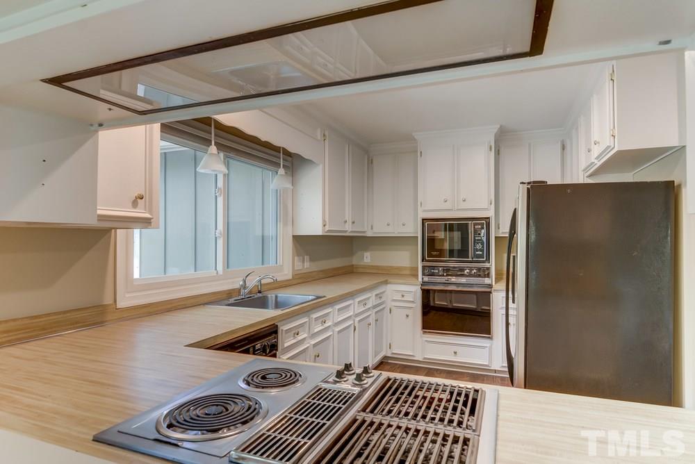 2921 Rue Sans Famille Raleigh, NC 27607 - Photo 7 of 15 a kitchen with stainless steel appliances a refrigerator and a stove