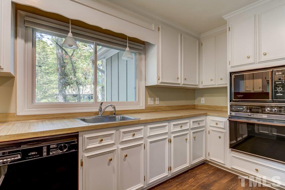 2921 Rue Sans Famille Raleigh, NC 27607 - Photo 8 of 15 a kitchen with granite countertop a stove a sink and a microwave