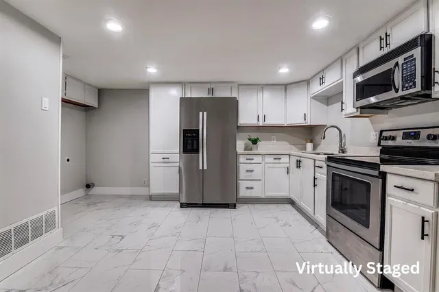 a kitchen with granite countertop a refrigerator and a stove top oven