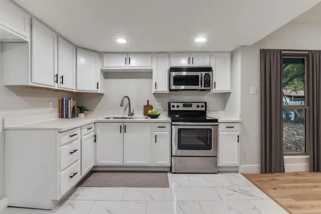 a kitchen with white cabinets and stainless steel appliances