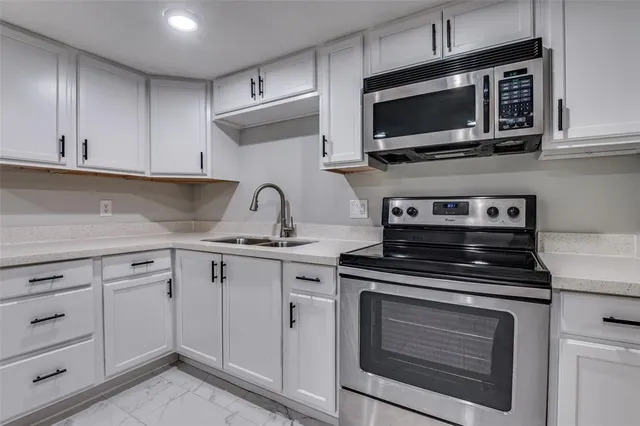 a kitchen with cabinets stainless steel appliances and a sink