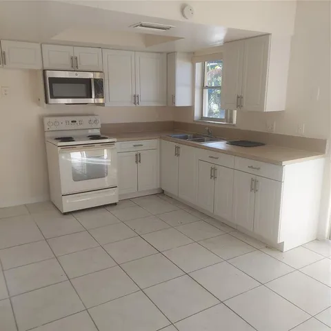 a kitchen with cabinets stainless steel appliances and a window