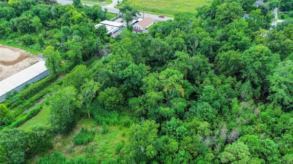an aerial view of residential house with outdoor space and trees all around