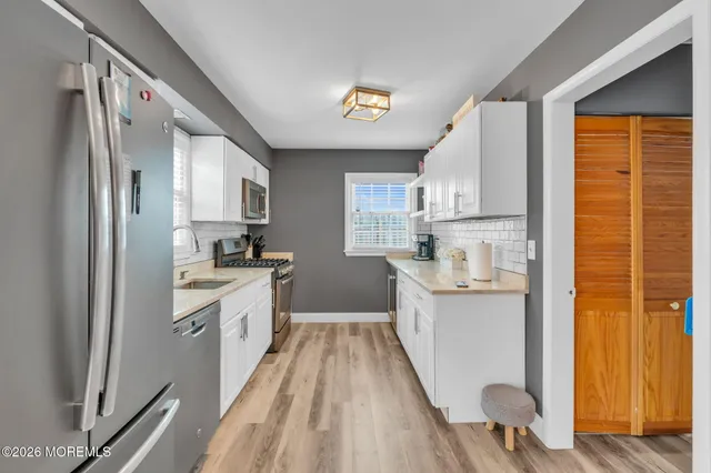 a large kitchen with a lot of counter space and wooden floor