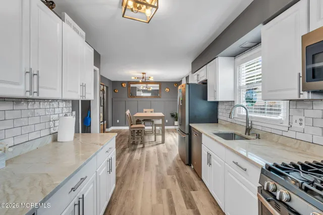 a kitchen with stainless steel appliances granite countertop a sink stove and cabinets