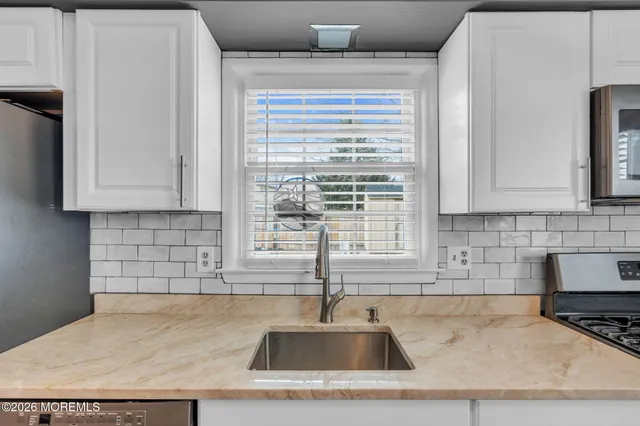 a kitchen with granite countertop a sink and a white stove