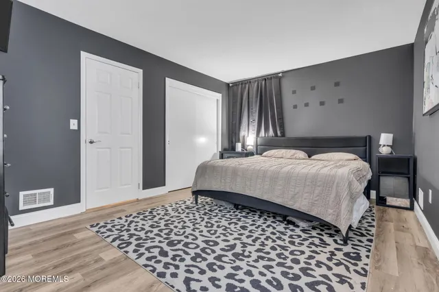 a bedroom with a bed and wooden floor