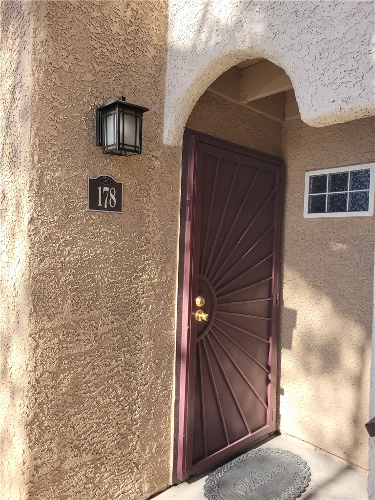 9325 West Desert Inn Road, Unit 178 Las Vegas, NV 89117 - Photo 2 of 20 An arched entryway features textured stucco walls and a decorative security door.