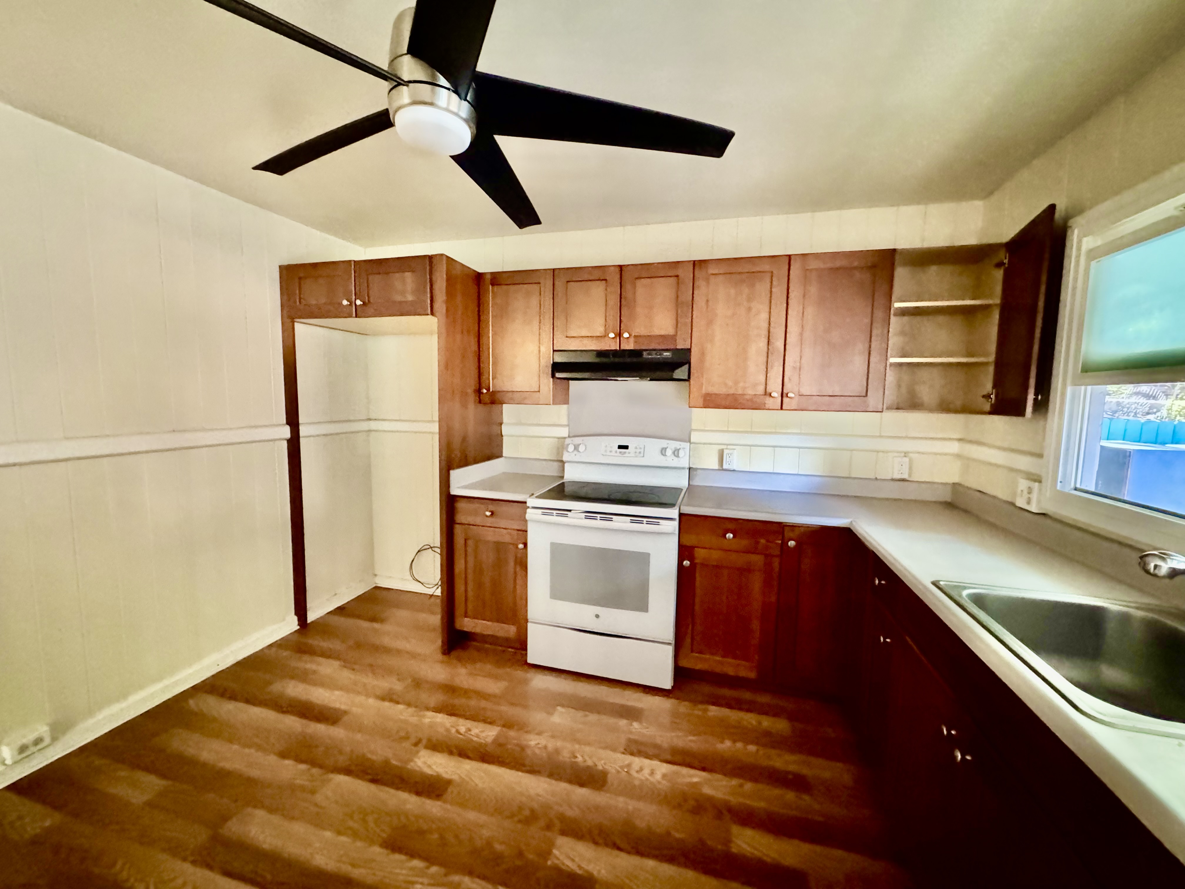 4611 Menehune Road, Unit 2 Waimea, HI 96796 - Photo 13 of 25 a kitchen with stainless steel appliances granite countertop a sink a stove and a refrigerator