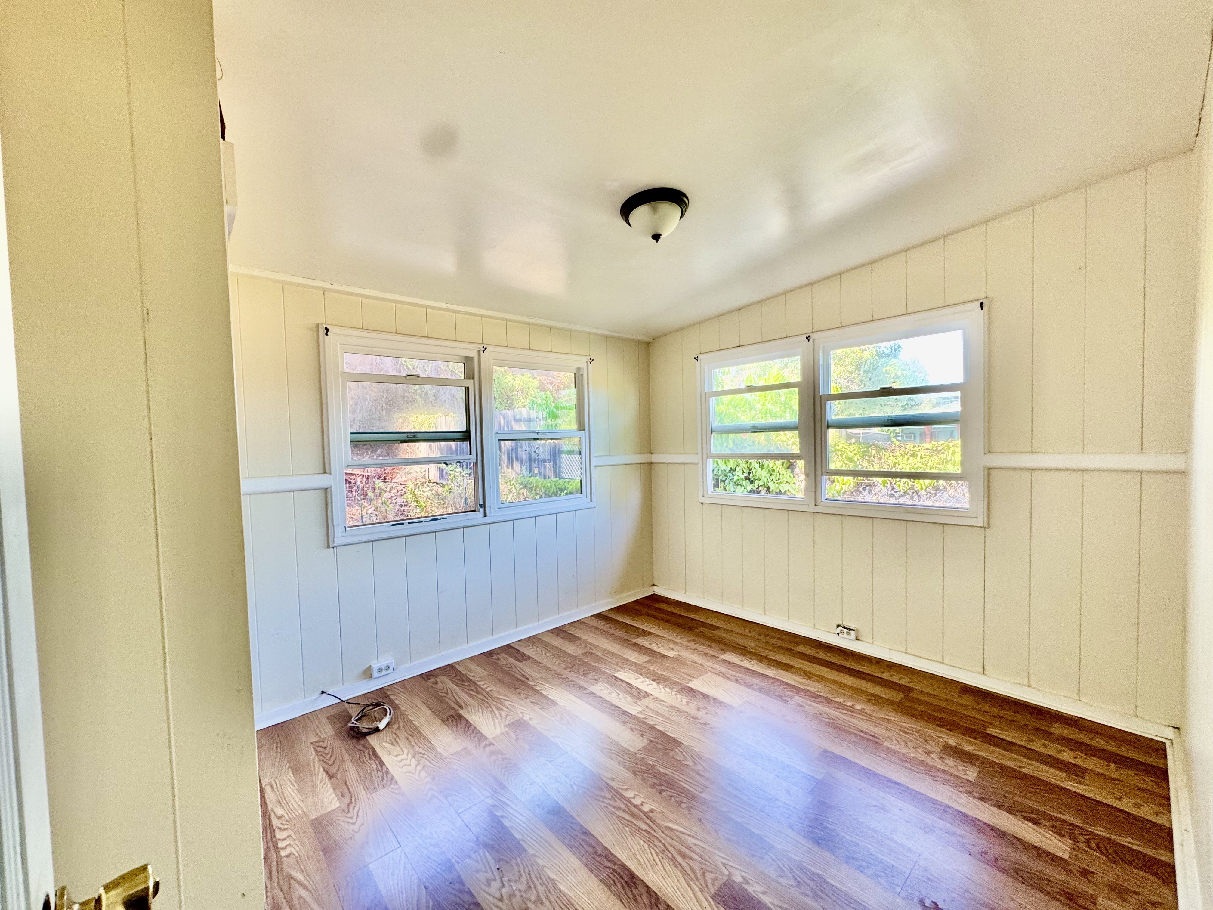 4611 Menehune Road, Unit 2 Waimea, HI 96796 - Photo 16 of 25 an empty room with wooden floor and windows