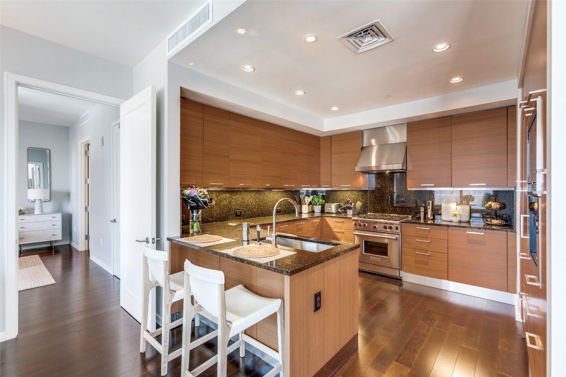 200 Congress Avenue, Unit 23B Austin, TX 78701 - Photo 5 of 9 a kitchen with stainless steel appliances granite countertop refrigerator sink and stove