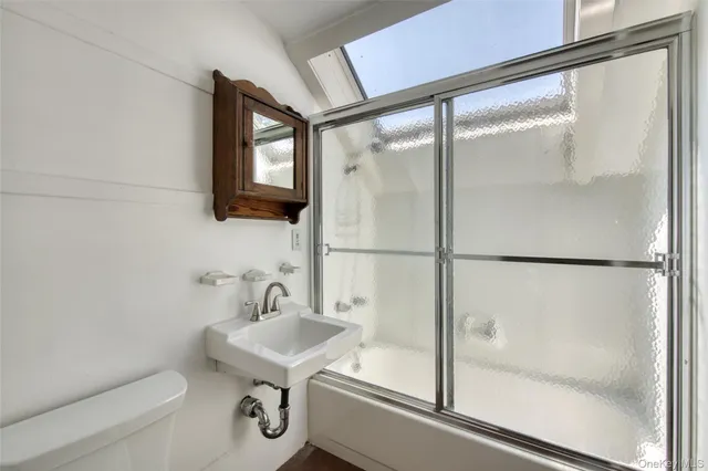 an empty room with chandelier fan and windows
