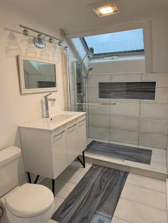 an empty room with chandelier fan and windows