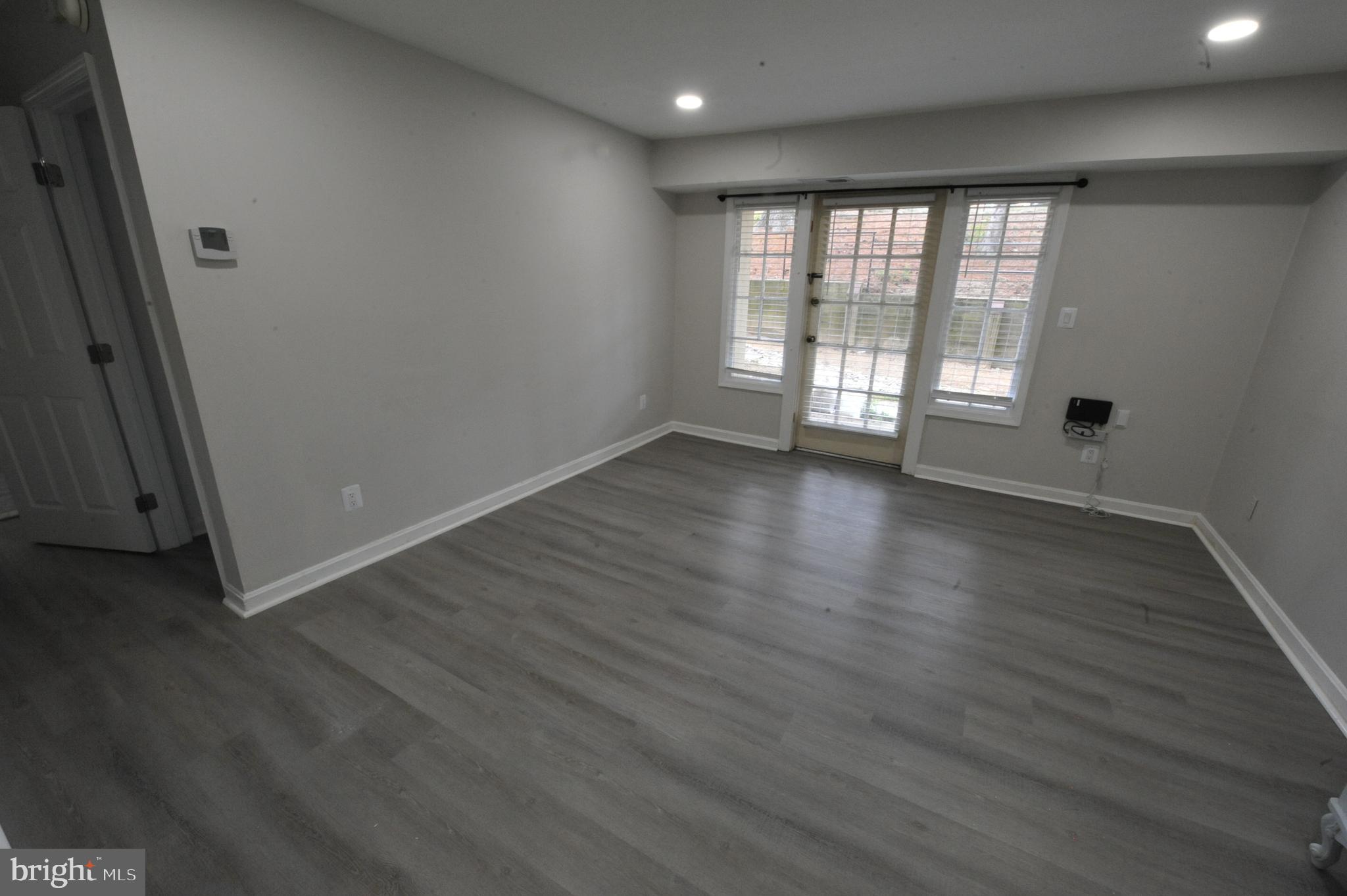 5900 K Surrey Hill Place, Unit 697 Springfield, VA 22152 - Photo 12 of 32 an empty room with wooden floor and windows