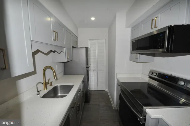 a view of a kitchen with a sink and dishwasher a refrigerator with wooden floor