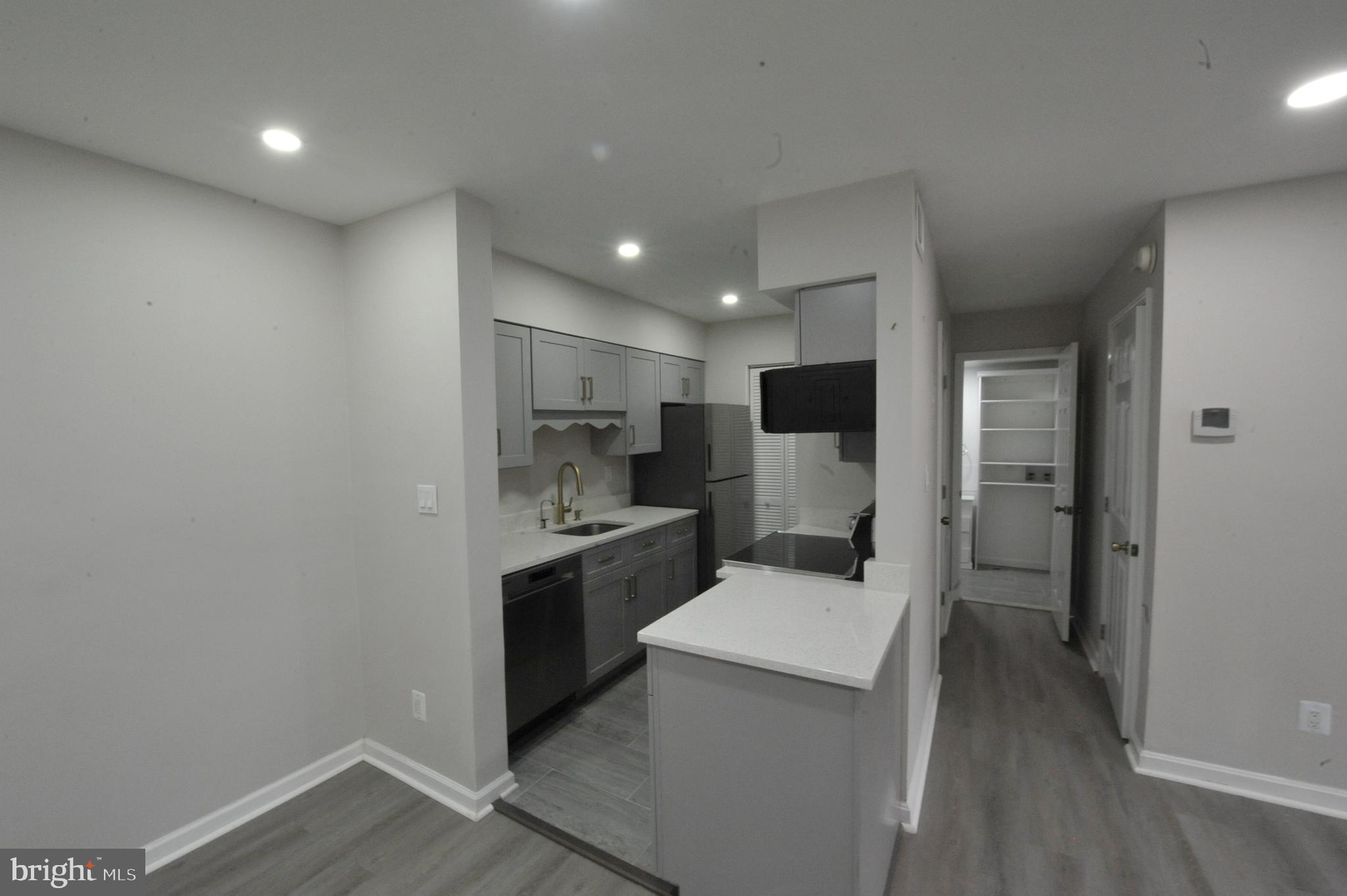 5900 K Surrey Hill Place, Unit 697 Springfield, VA 22152 - Photo 16 of 32 a view of a kitchen with a sink and dishwasher a refrigerator with wooden floor