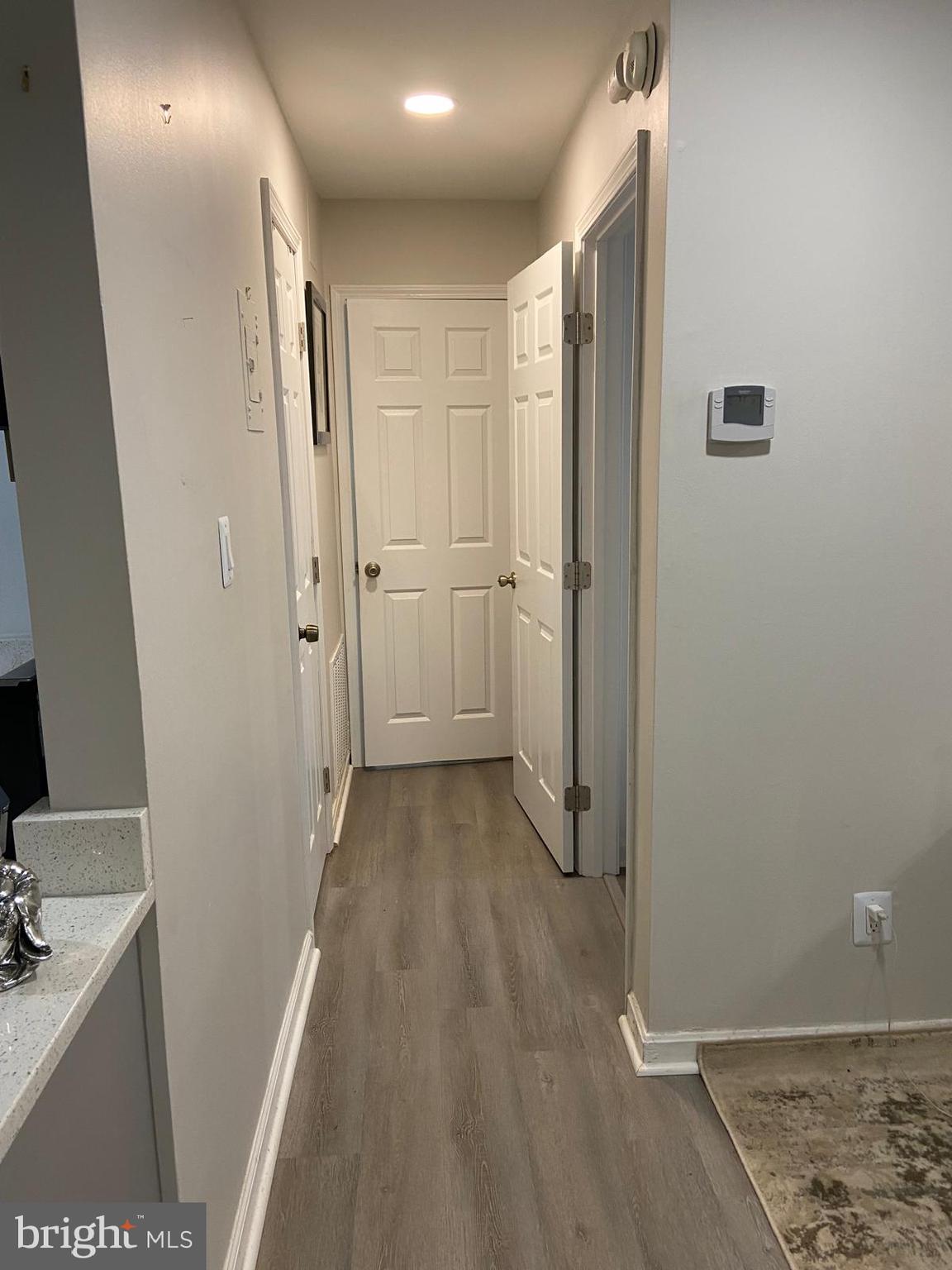 5900 K Surrey Hill Place, Unit 697 Springfield, VA 22152 - Photo 6 of 32 a view of a hallway with wooden floor and a bathroom