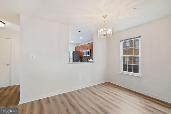 a view of an empty room with wooden floor and windows