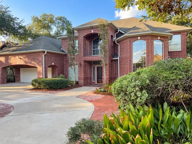 front view of a brick house with a small yard