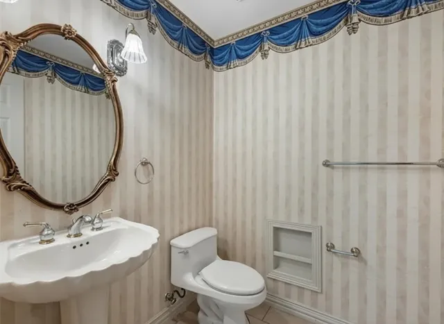 a bathroom with a sink a toilet and shower curtain