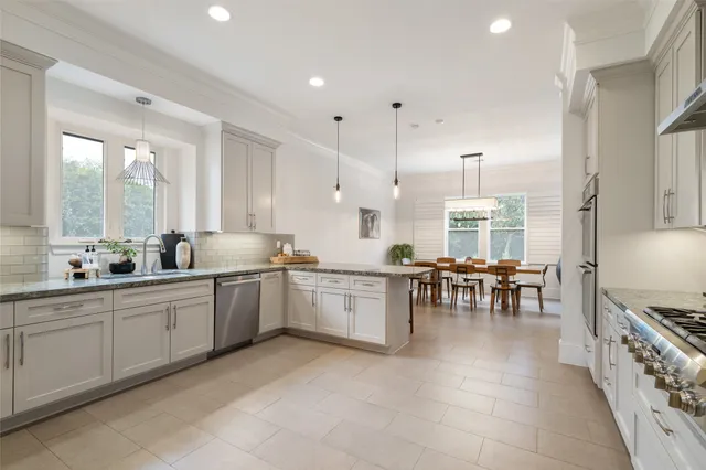 a large kitchen with lots of counter top space and dining table