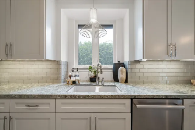 a kitchen with granite countertop a sink and a window