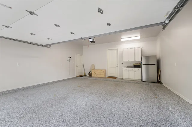 a view of a kitchen with a refrigerator and white cabinets