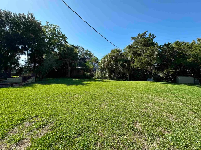 a view of a field of grass and trees