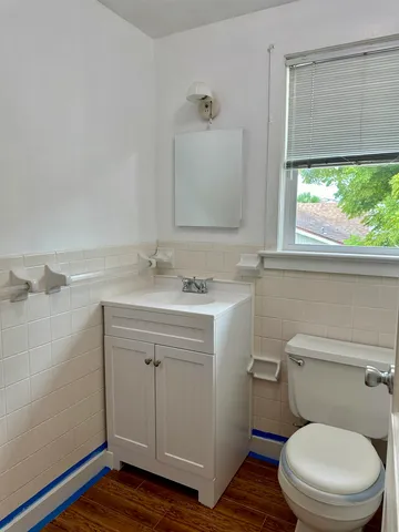 a bathroom with a sink a toilet and a window