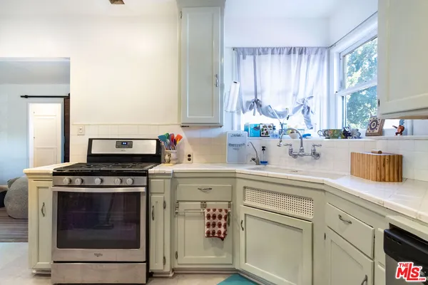 a kitchen with cabinets appliances and a window