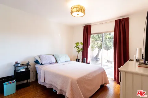 a bedroom with a bed and a dresser next to a window