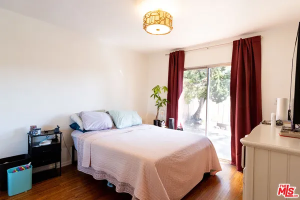 a bedroom with a bed and a dresser next to a window