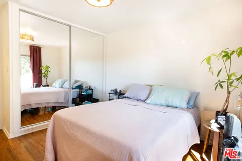 a bedroom with two beds and a potted plant