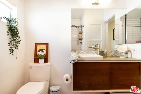 a bathroom with a granite countertop sink mirror vanity and toilet
