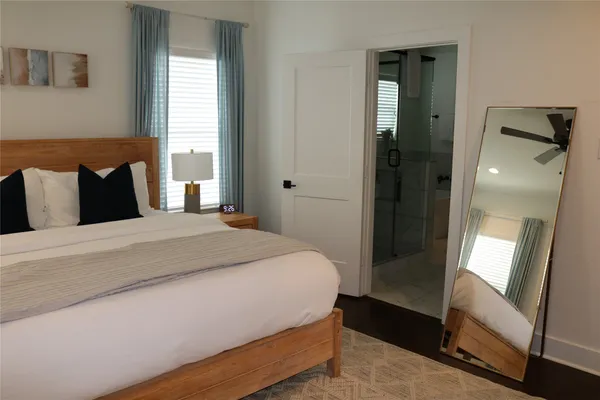 a bedroom with a bed and large mirror