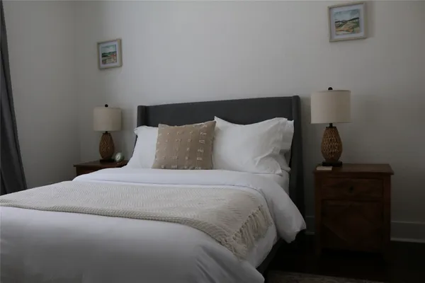 a bedroom with a bed and a lamp on the dresser